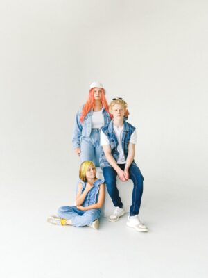 Trendy group of teens in denim fashion posing in studio setting.