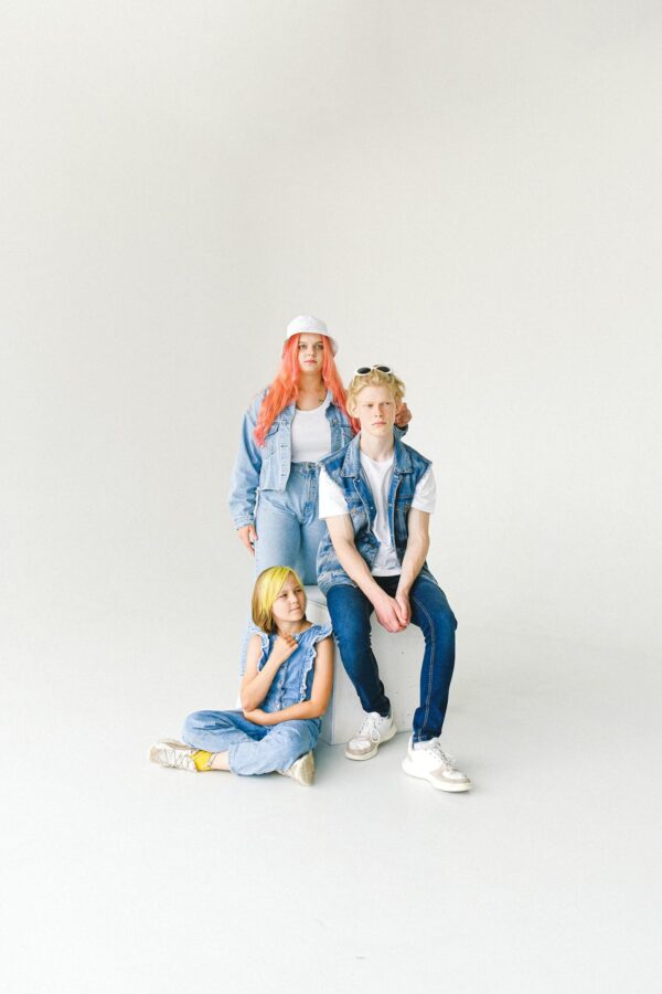 Trendy group of teens in denim fashion posing in studio setting.