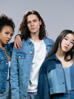 Trendy young adults in denim outfits showcasing diversity and modern style in a studio portrait.